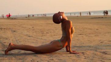 Девушка занимается йогой на пляже